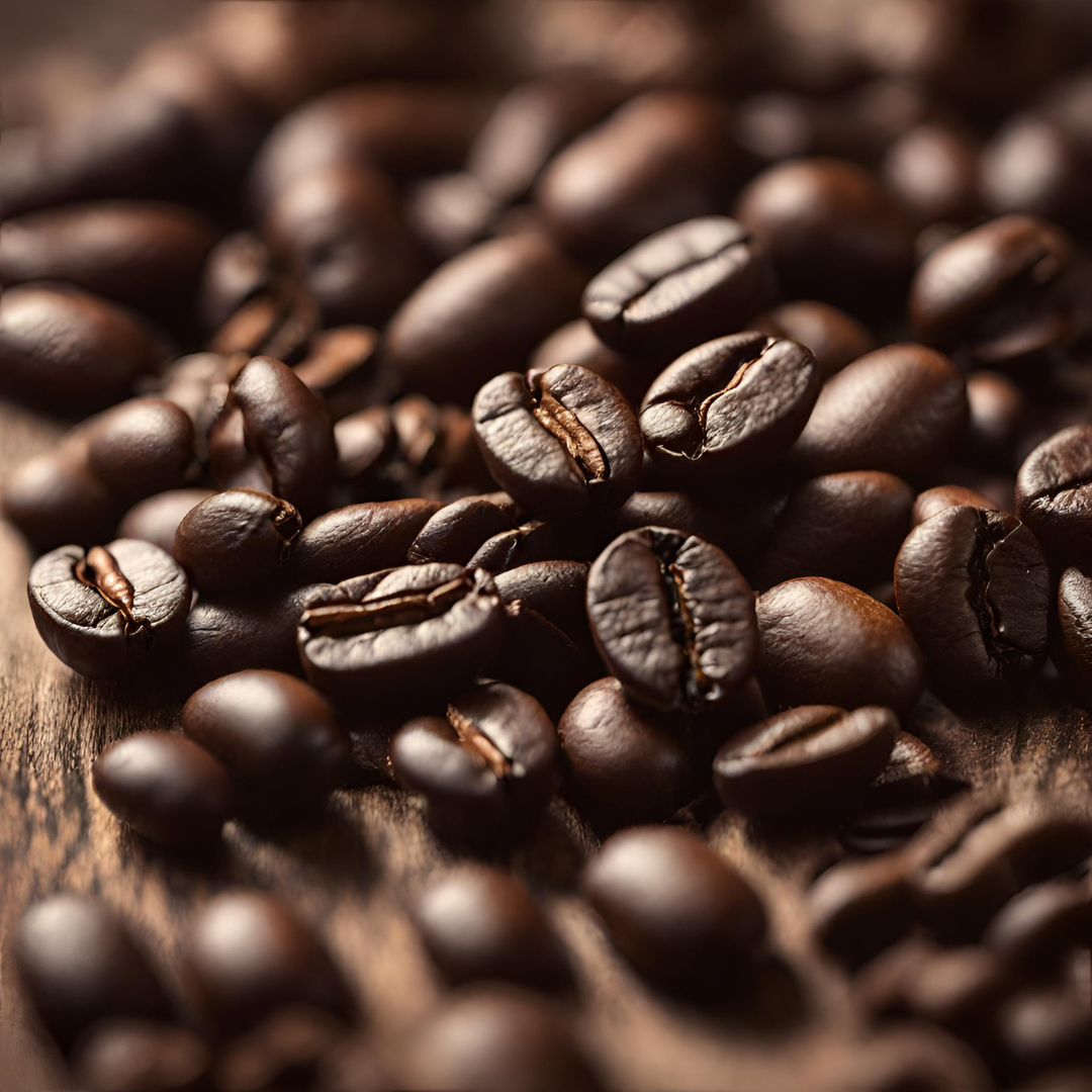 Close-up of roasted coffee beans scattered on a wooden surface, highlighting the rich brown color and textured creases of the beans.