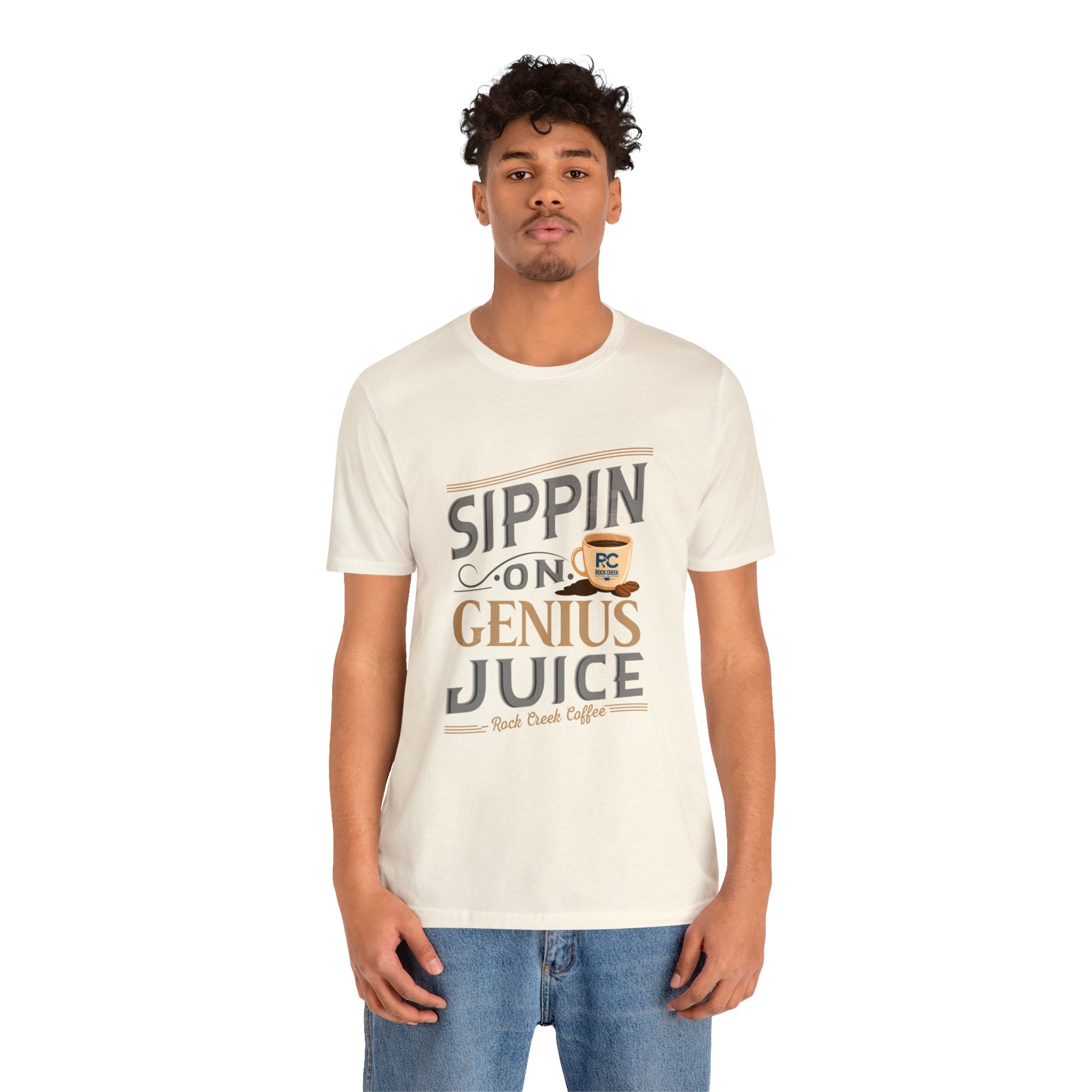 Adult man modeling a cream short-sleeve T-shirt printed with the phrase “Sippin on Genius Juice” in a bold coffee-themed graphic with a small coffee cup illustration, shown against a plain white background.