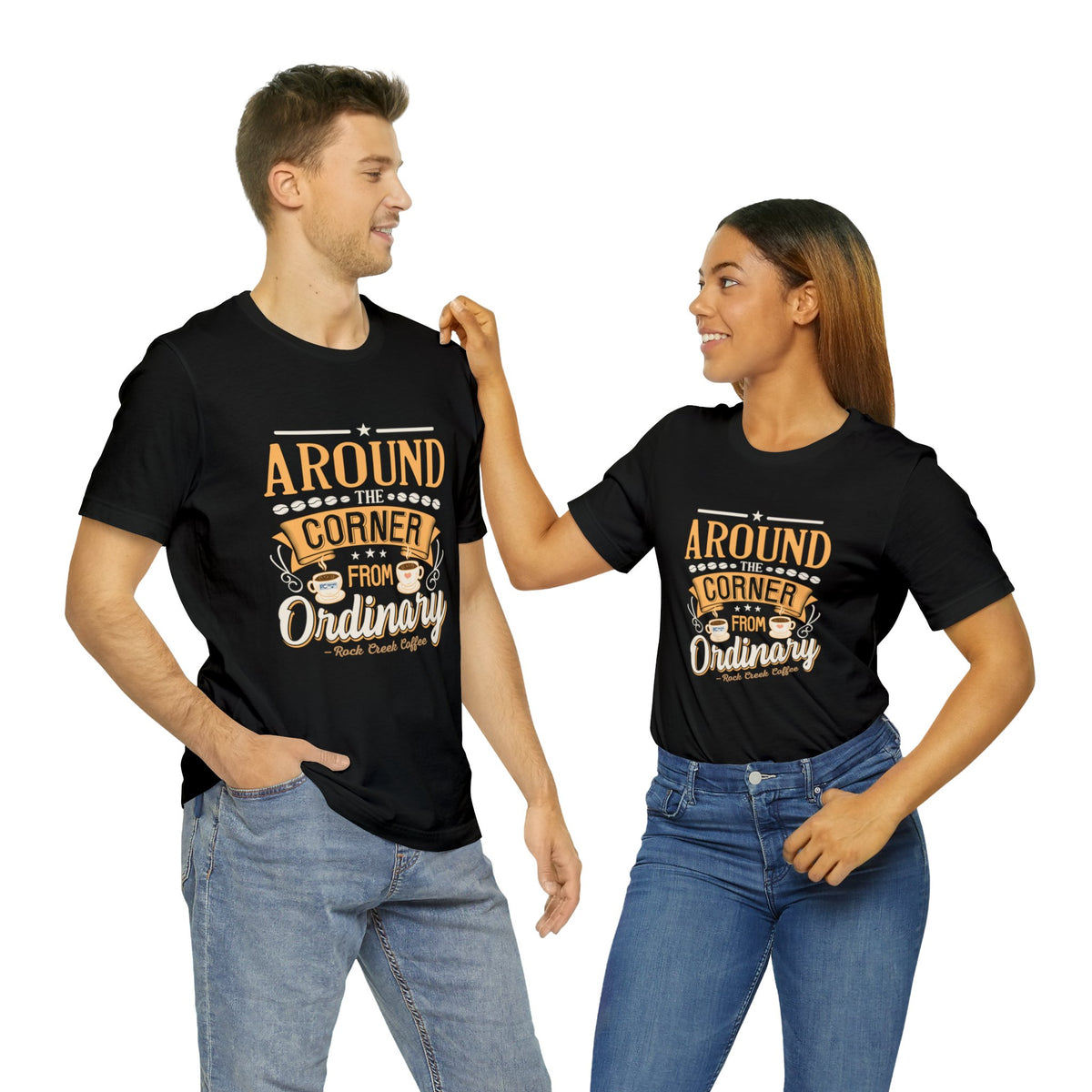 Two models wearing matching black Rock Creek Coffee T-shirts featuring the “Around the Corner From Ordinary” graphic design
