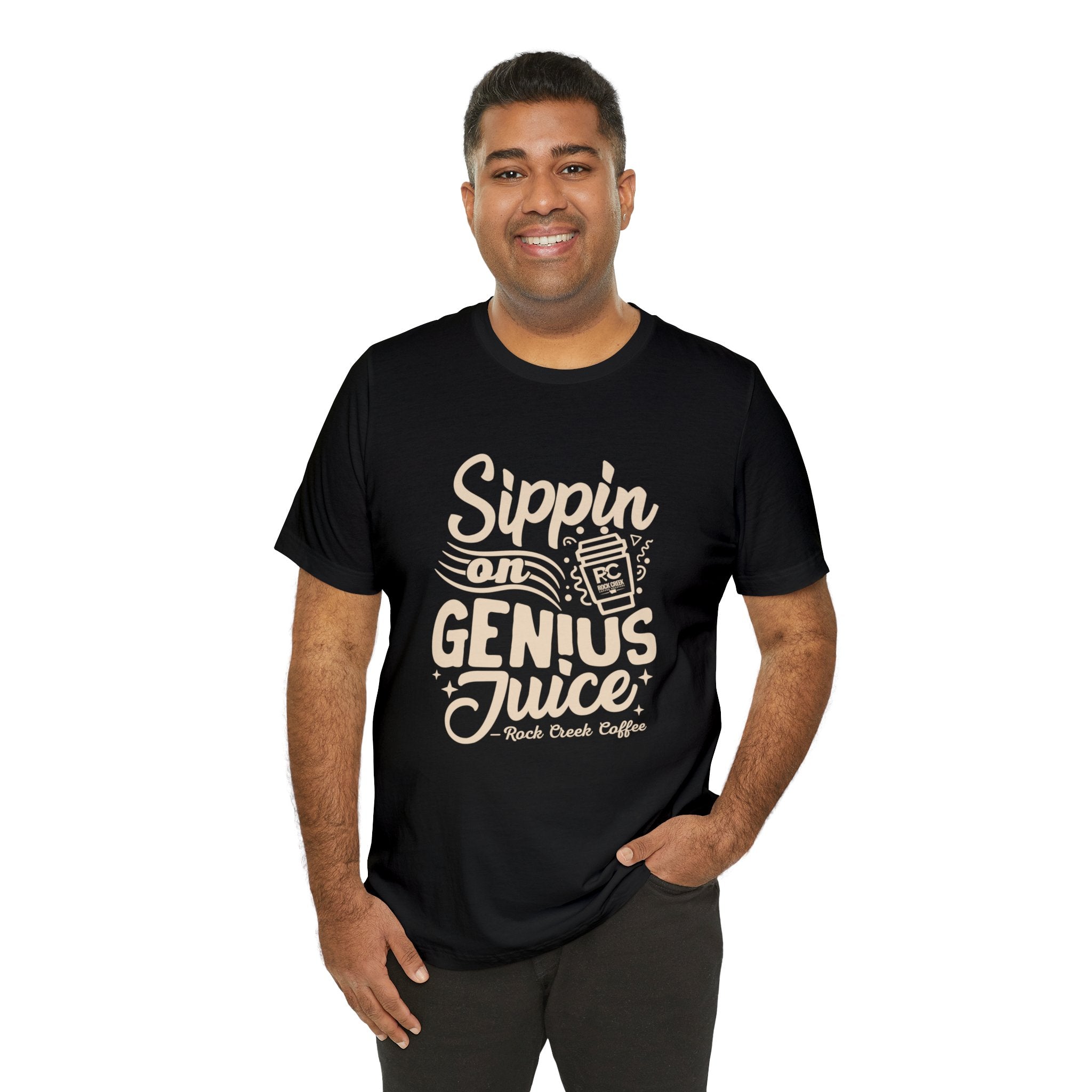 Smiling man modeling a black short-sleeve T-shirt printed with the coffee slogan “Sippin on Genius Juice” and a stylized to-go cup graphic on the front, shown against a white background.