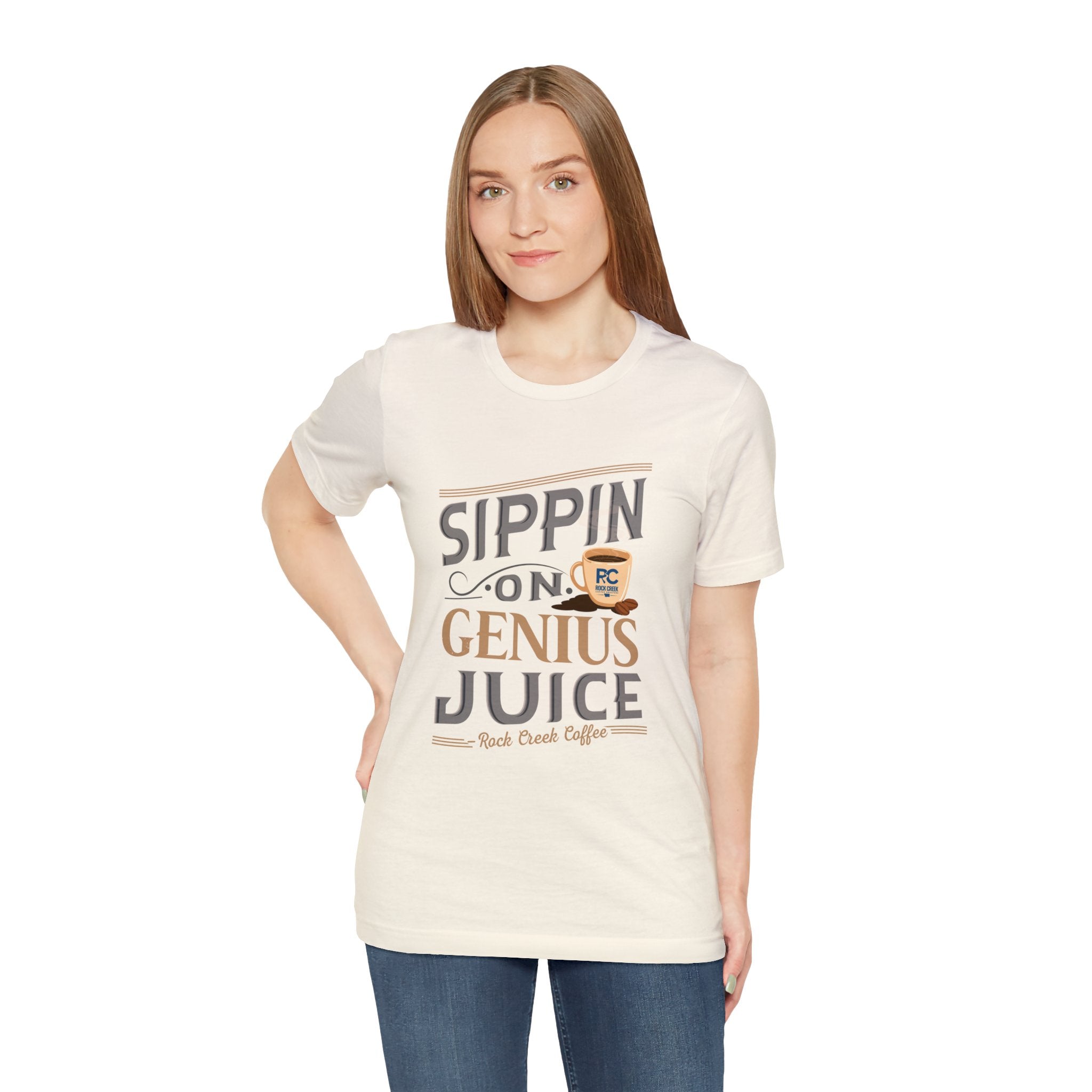 Adult woman modeling a cream short-sleeve T-shirt featuring the phrase “Sippin on Genius Juice” in a bold coffee-inspired graphic with a small mug illustration, shown against a plain white background.
