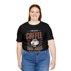 Adult woman smiling while modeling a black short-sleeve T-shirt featuring the “Fueled by Coffee and Dad Jokes” graphic with a coffee cup illustration and Rock Creek Coffee text, shown against a plain white background.
