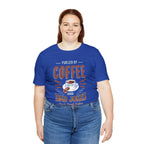 Adult woman smiling while modeling a royal blue short-sleeve T-shirt featuring the “Fueled by Coffee and Dad Jokes” graphic with a coffee cup illustration and Rock Creek Coffee text, shown against a plain white background.