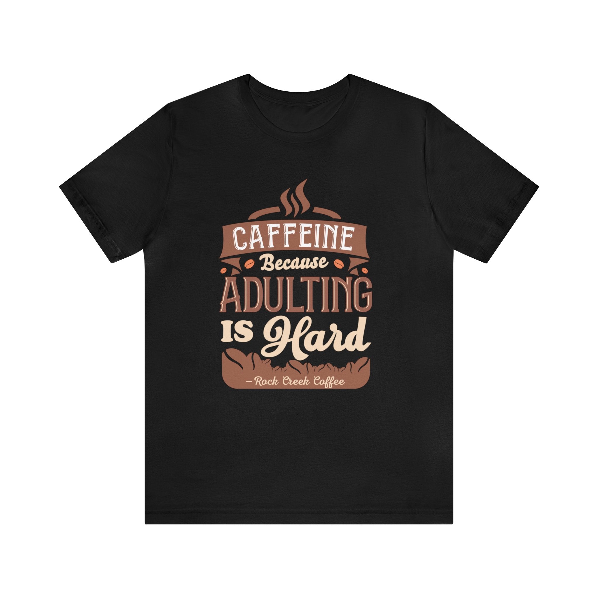 Black short-sleeve T-shirt displayed flat against a plain white background, featuring the phrase “Caffeine Because Adulting Is Hard” in a stacked typographic design with Rock Creek Coffee branding below.