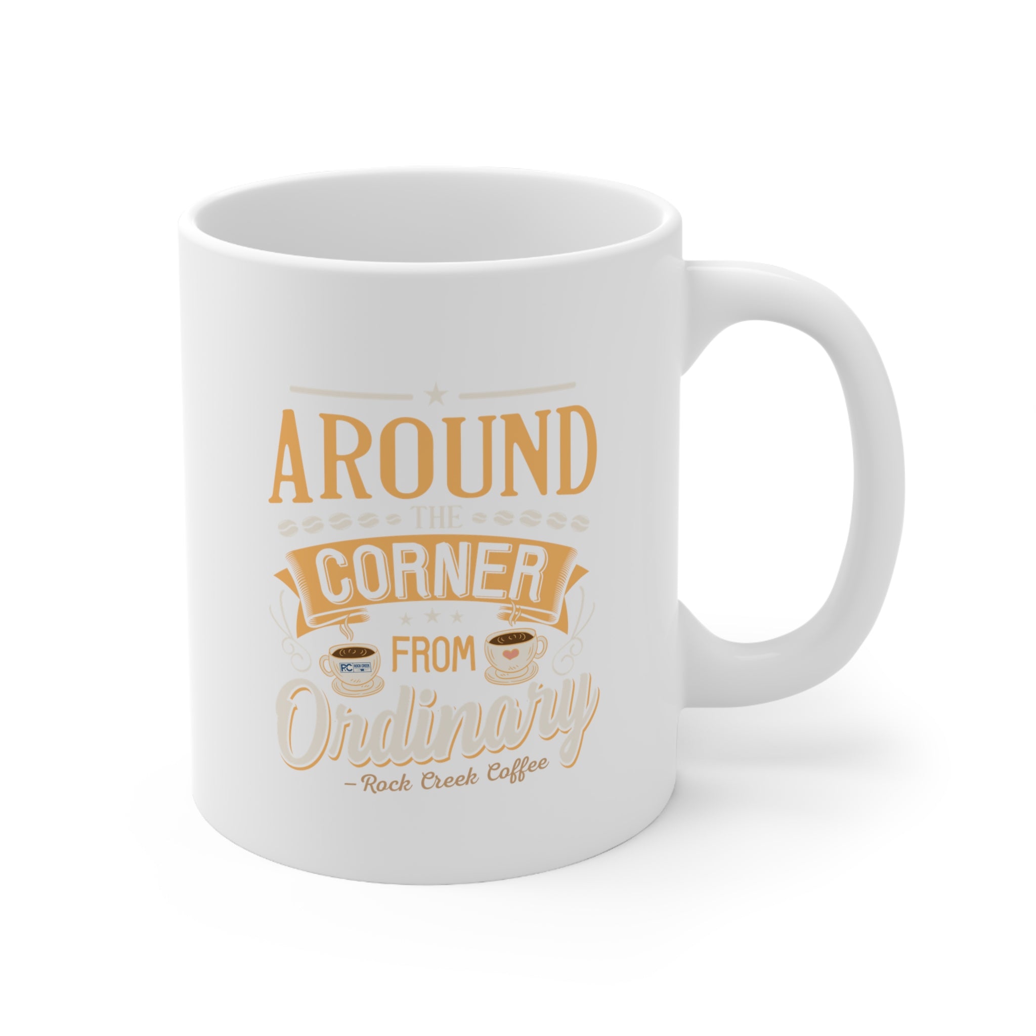 White ceramic Rock Creek Coffee mug with “Around the Corner from Ordinary” design in warm gold and cream lettering, featuring small coffee cup illustrations, shown on a clean white background.