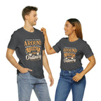Adult man and woman modeling matching asphalt gray short-sleeve T-shirts featuring the “Around the Corner from Ordinary” graphic in a bold coffee-themed typographic design, posed together against a plain white background.