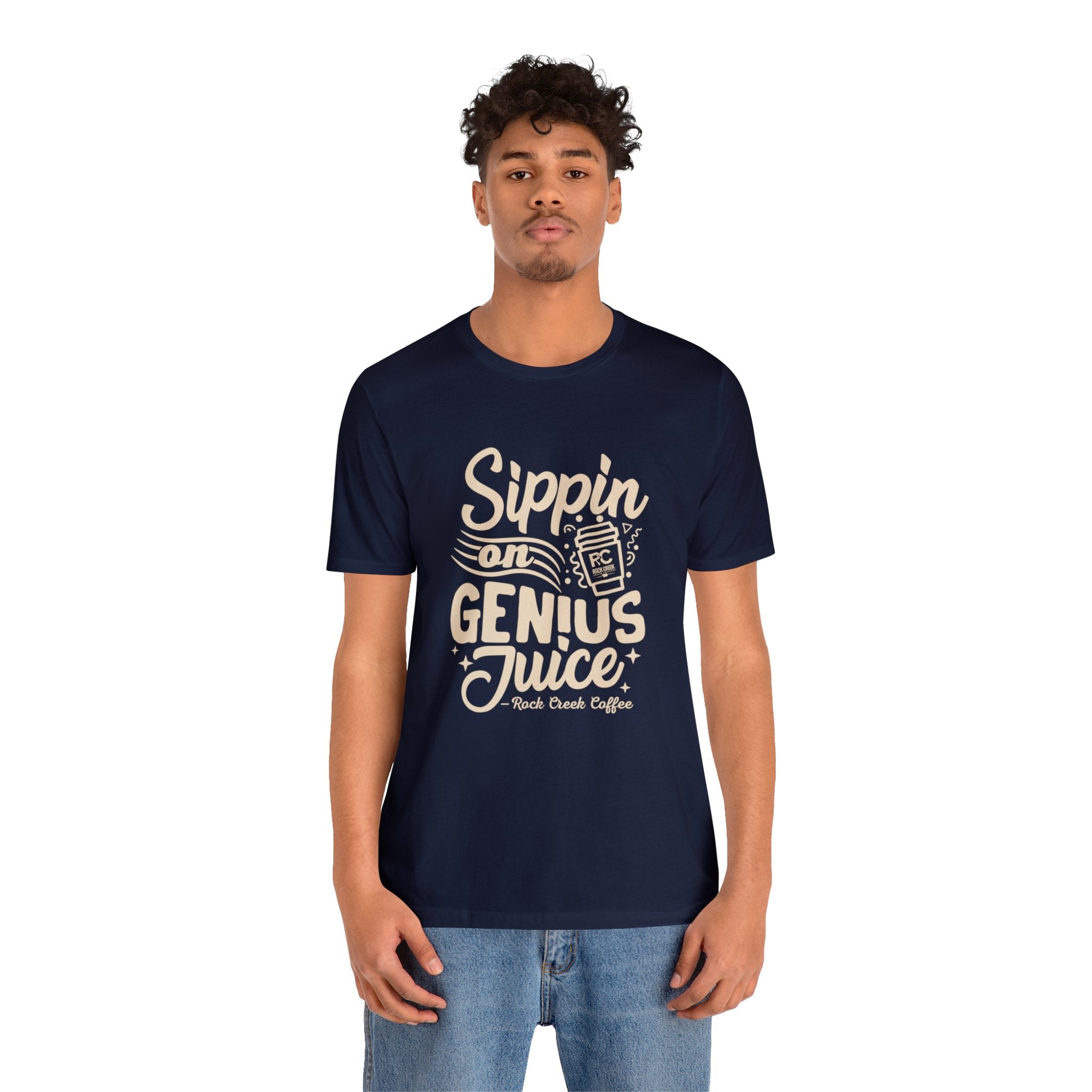 Adult man modeling a navy short-sleeve T-shirt printed with the slogan “Sippin on Genius Juice” and a stylized coffee to-go cup graphic on the front, shown against a plain white background.