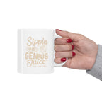 Hand with red nail polish holding a white Rock Creek Coffee mug featuring “Sippin on Genius Juice” in beige lettering with a small RC coffee cup graphic on a white background.