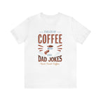 White short-sleeve T-shirt displayed flat against a plain white background, featuring the “Fueled by Coffee and Dad Jokes” graphic with a coffee cup illustration and Rock Creek Coffee text below.
