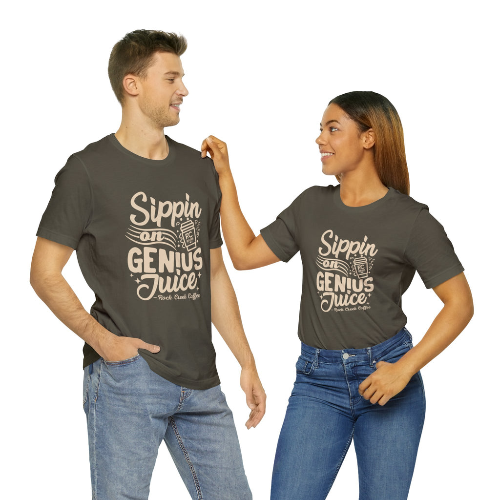 Smiling man and woman standing side by side, both wearing olive green short-sleeve T-shirts printed with the slogan “Sippin on Genius Juice” and stylized coffee to-go cup graphics on the front, against a plain white background.