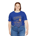 Adult woman smiling while modeling a royal blue short-sleeve T-shirt featuring the “Sippin on Genius Juice” graphic in bold coffee-inspired lettering with a small mug illustration, shown against a plain white background.