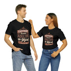 Adult man and woman modeling matching black short-sleeve T-shirts featuring the “Caffeine Because Adulting Is Hard” graphic in a stacked typographic design, posed together against a plain white background.