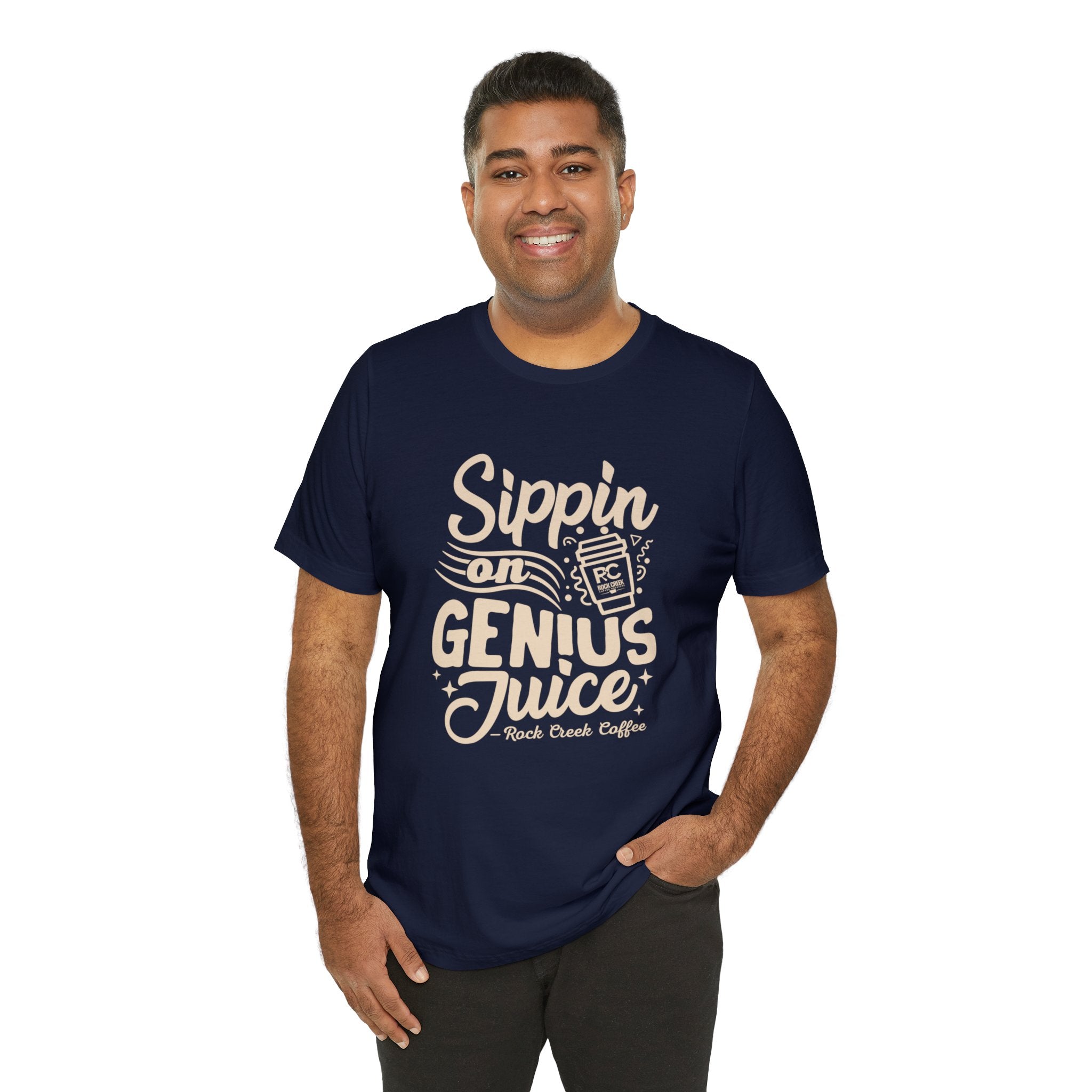 Smiling man modeling a navy short-sleeve T-shirt printed with a coffee-themed slogan “Sippin on Genius Juice” and a stylized coffee cup graphic on the front, shown against a plain white background.