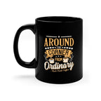 Black ceramic coffee mug with a glossy finish featuring the Around the Corner from Ordinary Rock Creek Coffee design in gold and white lettering with decorative stars and coffee cup illustrations.