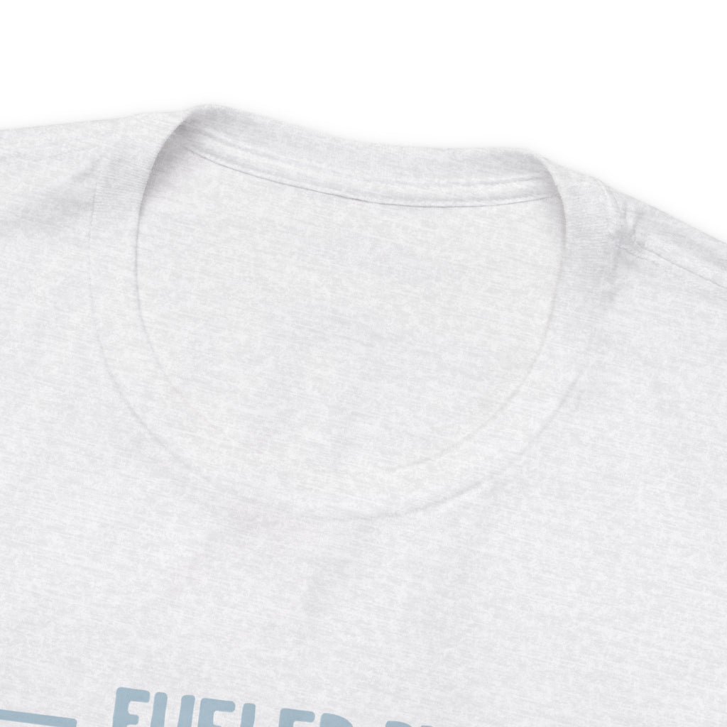 Close-up detail of an ash crew neck T-shirt showing the neckline and upper chest area, with the top edge of the “Fueled by Coffee and Dad Jokes” graphic partially visible against a plain white background.