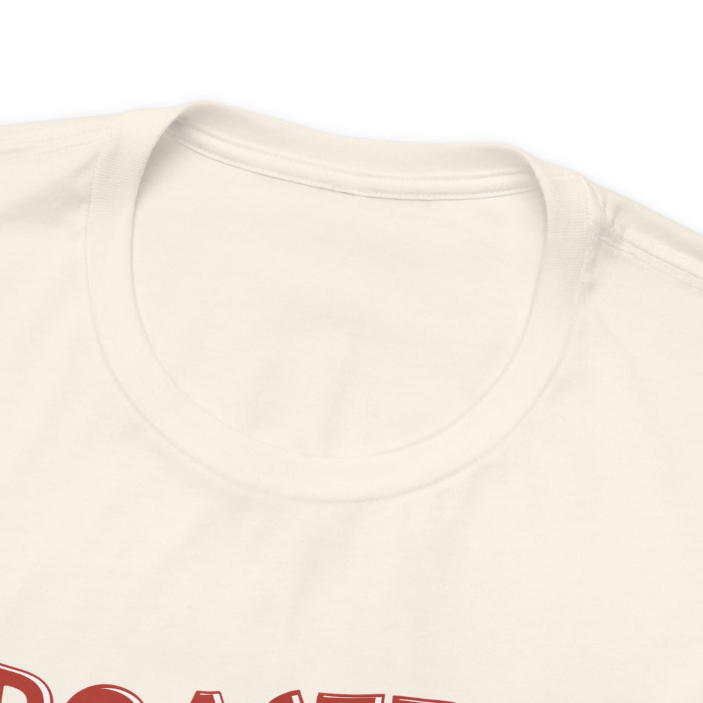 Detailed product close-up of a cream Seattle coffee graphic T-shirt showing the upper portion of the “Roasted 818 Miles East of Seattle” design.