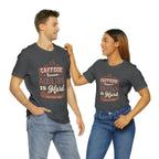 Adult man and woman modeling matching asphalt short-sleeve T-shirts featuring the “Caffeine Because Adulting Is Hard” graphic in a stacked typographic design, posed together against a plain white background.