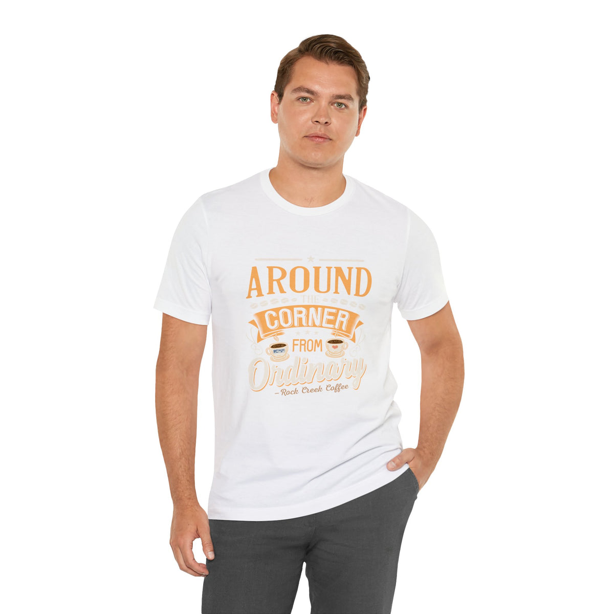 Male model wearing a white Rock Creek Coffee T-shirt featuring the “Around the Corner From Ordinary” graphic print