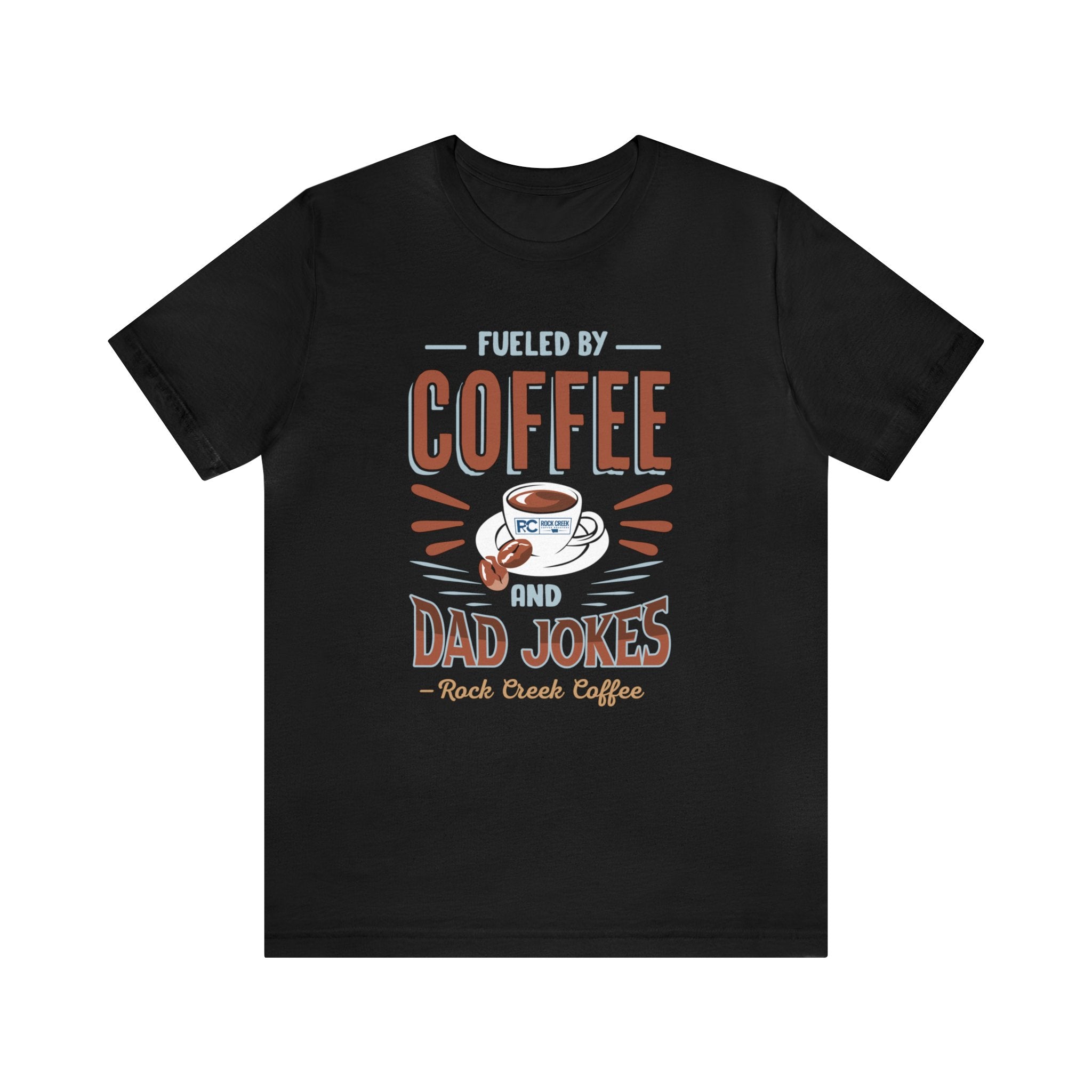 Black short-sleeve T-shirt displayed flat against a plain white background, featuring a bold graphic that reads “Fueled by Coffee and Dad Jokes” with a coffee cup illustration and Rock Creek Coffee text below.