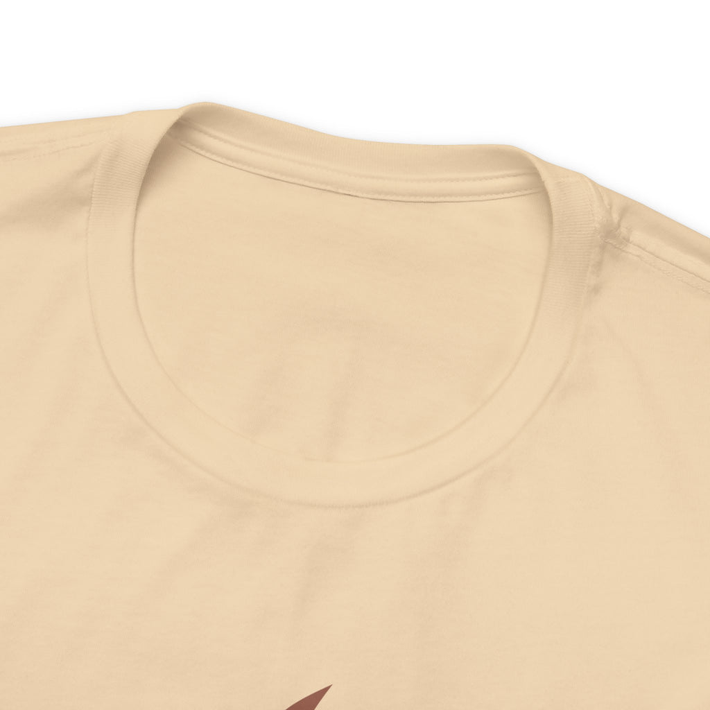Close-up detail of a soft cream crew neck T-shirt showing the neckline, collar stitching, and upper chest area, with only a small portion of the front graphic visible at the bottom edge against a plain white background.