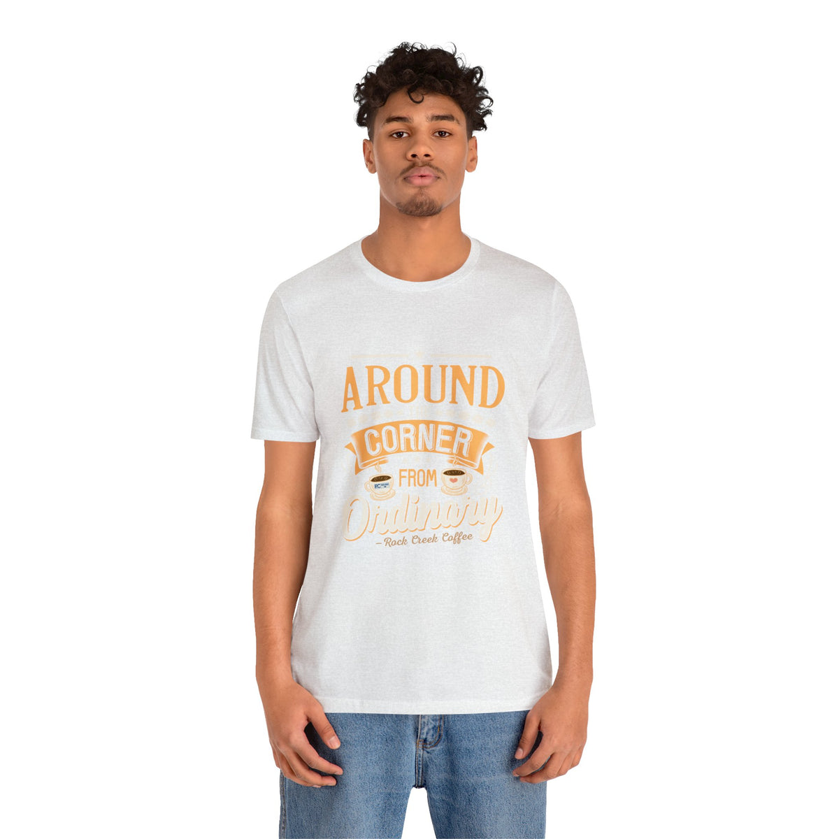 Male model wearing an ash Rock Creek Coffee T-shirt featuring the “Around the Corner From Ordinary” graphic print