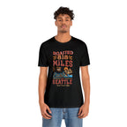 Adult man modeling a black short-sleeve Seattle coffee graphic T-shirt reading “Roasted 818 Miles East of Seattle,” shown against a plain white background.