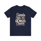 Navy blue short-sleeve T-shirt displayed flat against a white background featuring the “Sippin on Genius Juice” coffee-themed graphic with stylized lettering and a to-go cup illustration.