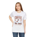 Adult woman modeling a white short-sleeve T-shirt featuring the “Fueled by Coffee and Dad Jokes” graphic with a coffee cup illustration and Rock Creek Coffee text, shown against a plain white background.