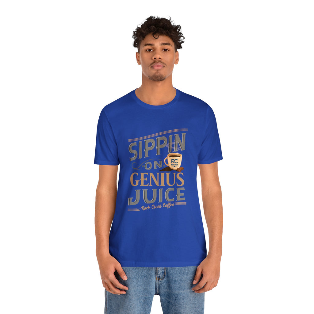 Adult man modeling a royal blue short-sleeve T-shirt featuring the “Sippin on Genius Juice” graphic in bold coffee-inspired lettering with a small mug illustration, shown against a plain white background.