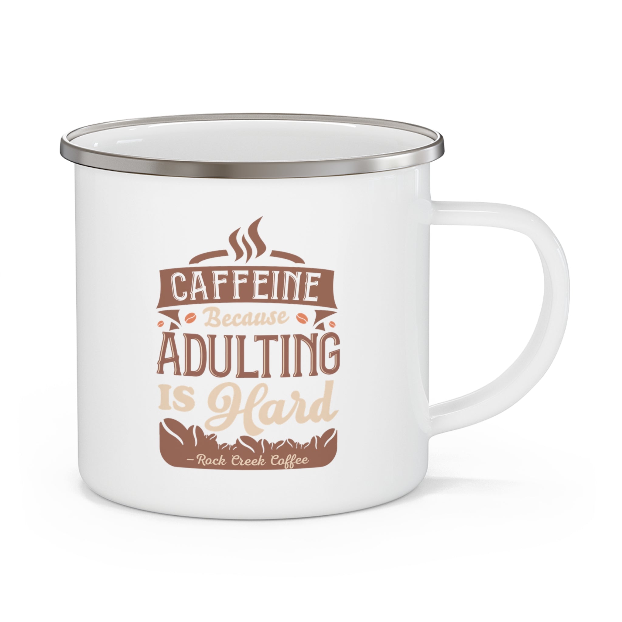 White enamel-style coffee mug with silver rim featuring the phrase “Caffeine Because Adulting Is Hard – Rock Creek Coffee” in brown and tan lettering, displayed against a white background.