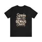 Black short-sleeve T-shirt displayed flat against a white background featuring a bold coffee-themed graphic that reads “Sippin on Genius Juice” with a stylized coffee to-go cup illustration.