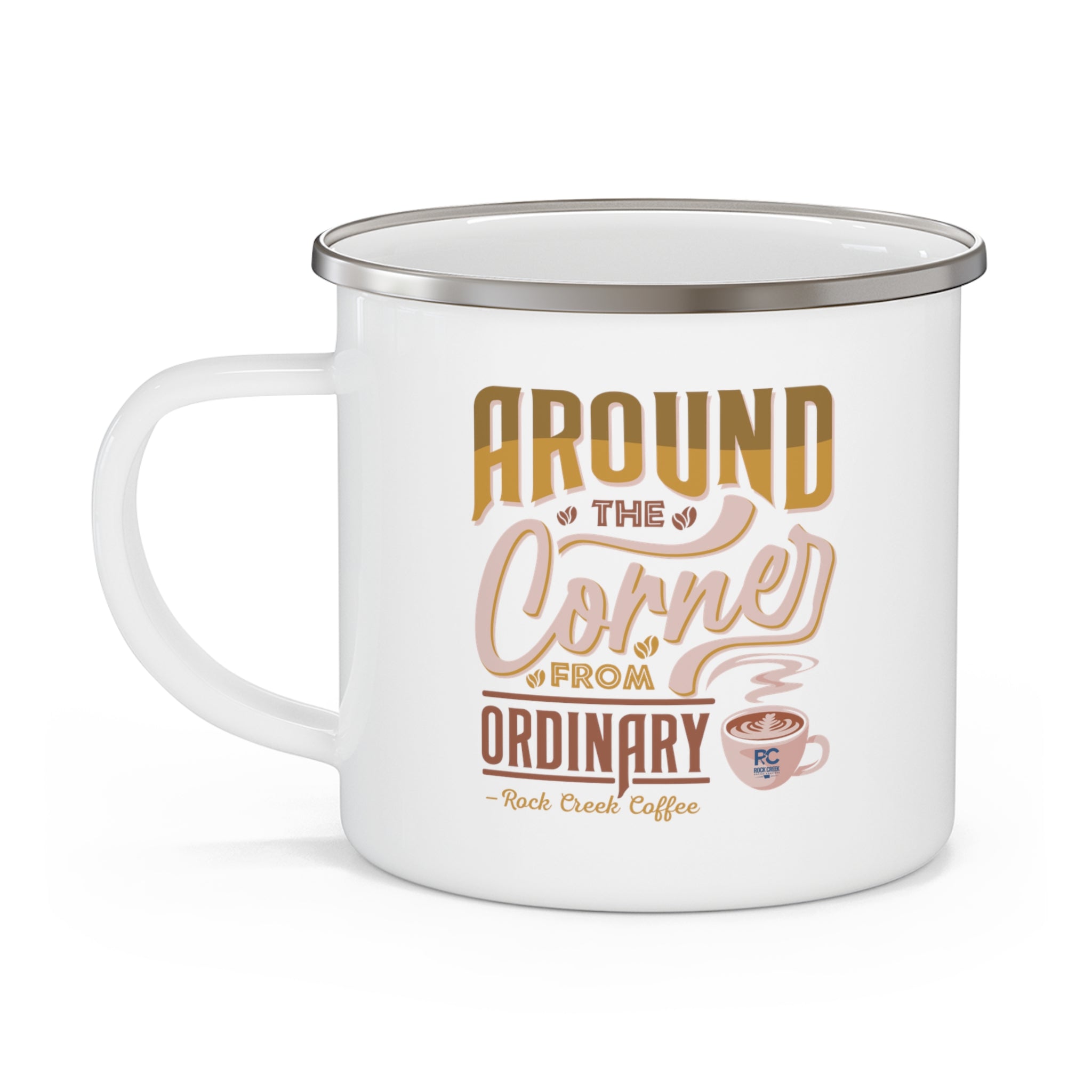 White enamel style coffee mug with silver rim and handle featuring the phrase Around the Corner from Ordinary Rock Creek Coffee in tan, gold, and brown lettering with a small latte cup illustration.