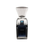 Front view of a Baratza Virtuoso Plus coffee grinder in black and stainless steel, featuring a clear bean hopper, grind size adjustment collar, digital timer display with control knob, and blue-tinted grounds bin on a white background.