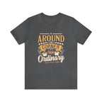 Asphalt gray short-sleeve T-shirt displayed flat against a plain white background, featuring the phrase “Around the Corner from Ordinary” in a bold coffee-themed typographic design with Rock Creek Coffee branding below.