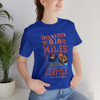Royal blue men’s Seattle coffee graphic T-shirt with “Roasted 818 Miles East of Seattle” artwork, modeled in a studio-style image on a white background.
