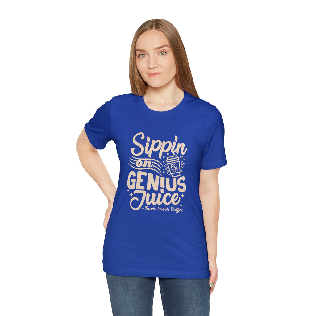 Adult woman modeling a royal blue short-sleeve T-shirt with a coffee-themed slogan that reads “Sippin on Genius Juice” and a stylized coffee cup graphic on the front, shown against a white background.