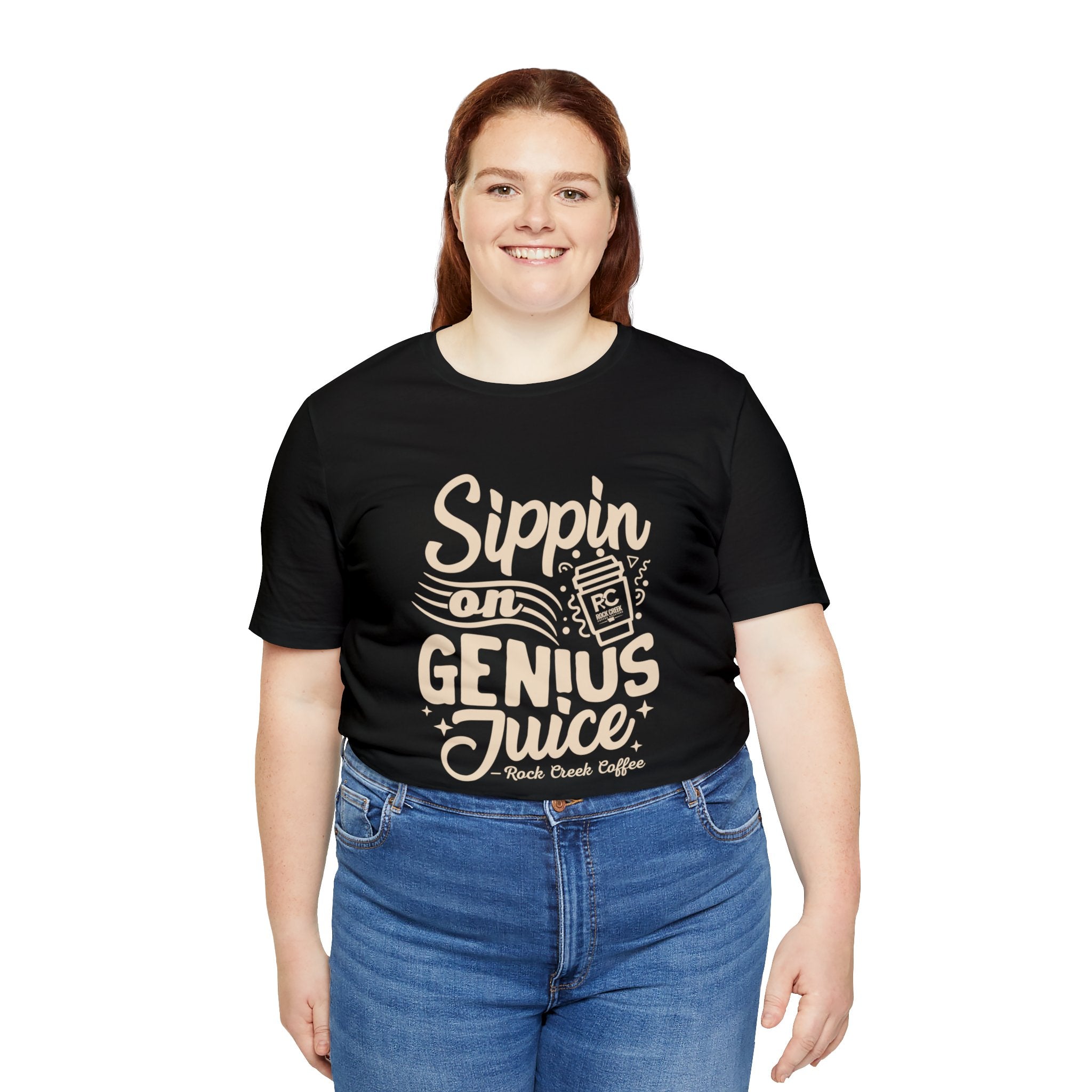 Smiling woman modeling a black short-sleeve T-shirt printed with the slogan “Sippin on Genius Juice” and a stylized coffee to-go cup graphic on the front, shown against a plain white background.