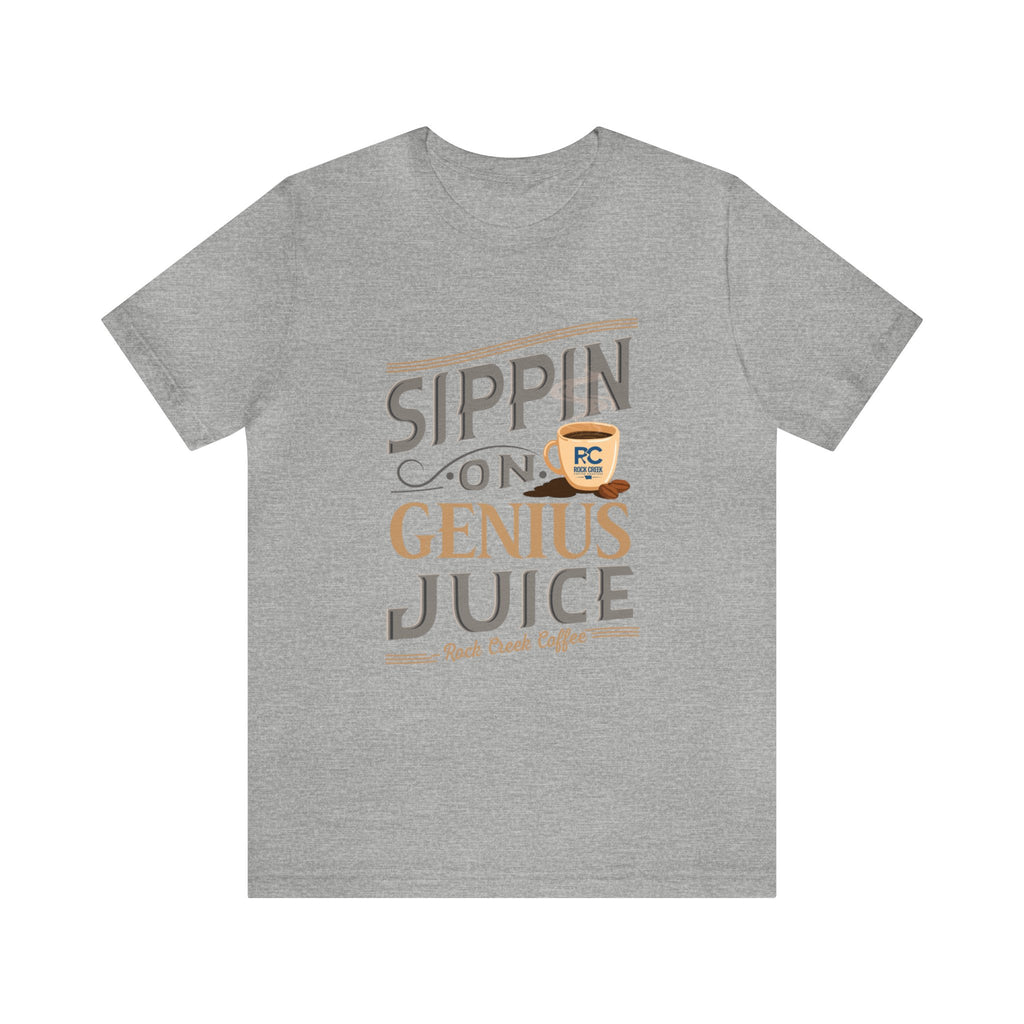 Heather gray short-sleeve T-shirt displayed flat against a plain white background, featuring the “Sippin on Genius Juice” graphic in large coffee-inspired lettering with a small mug illustration.