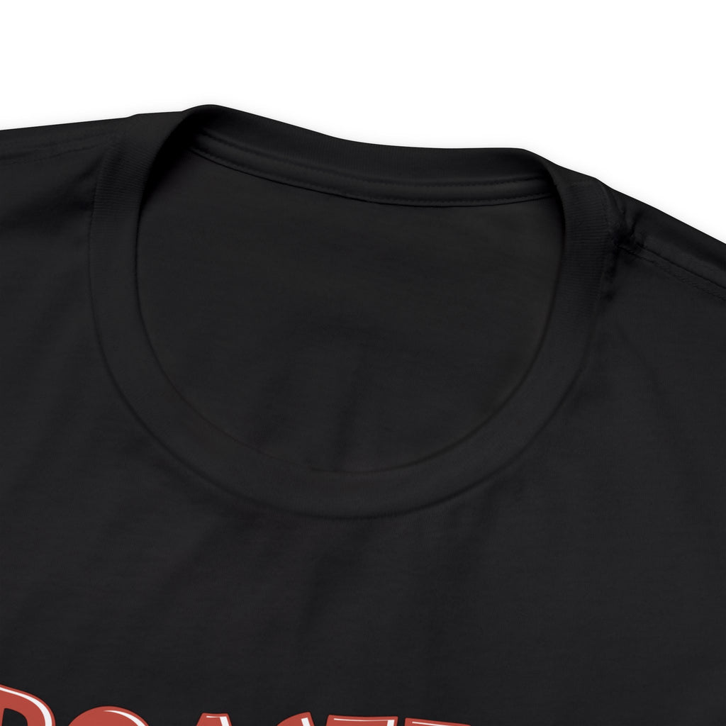 Close-up view of a black crew neck T-shirt showing the upper portion of the “Roasted 818 Miles East of Seattle” graphic, displayed against a plain white background.