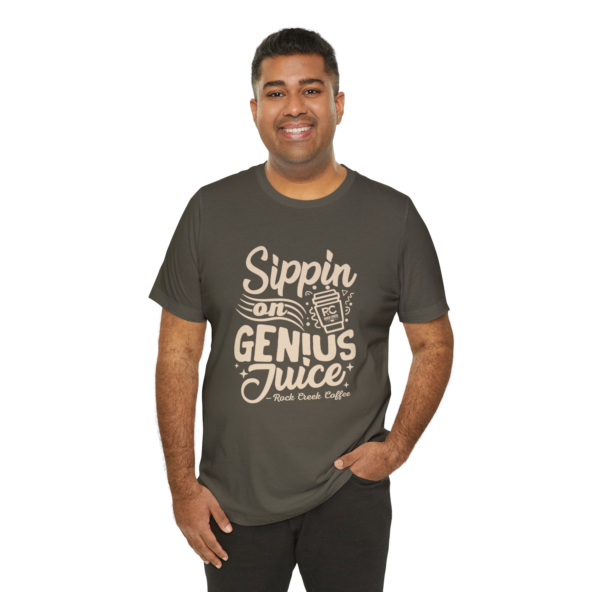 Smiling man modeling an olive green short-sleeve T-shirt with a coffee-themed slogan reading “Sippin on Genius Juice” and a stylized to-go cup graphic on the front, shown against a plain white background.