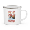 White enamel-style coffee mug with silver rim and handle featuring a colorful “Roasted 818 Miles East of Seattle - Rock Creek Coffee” design with a coffee cup and mountain illustration, displayed against a white background.