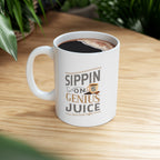 White Rock Creek Coffee mug featuring the phrase “Sippin on Genius Juice” in stylized gray and gold lettering with a small coffee cup graphic, filled with coffee and placed on a wooden surface with green plants blurred in the background.