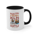White ceramic coffee mug with a black interior and handle featuring the Roasted 818 Miles East of Seattle Rock Creek Coffee design in red, blue, and brown lettering with a coffee cup and mountain illustration.