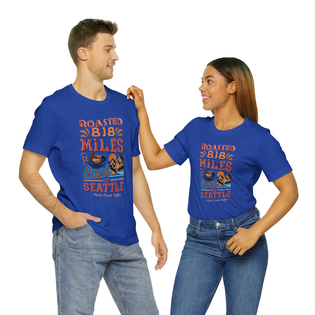 Matching royal blue Seattle coffee graphic T-shirts with “Roasted 818 Miles East of Seattle” print, modeled by an adult man and woman on a white studio background.