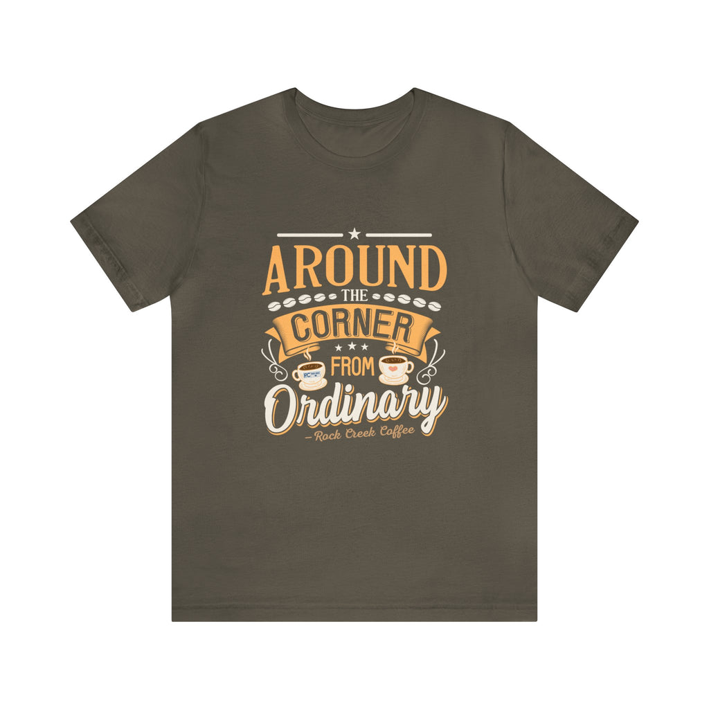Army green short-sleeve T-shirt displayed flat against a plain white background, featuring the phrase “Around the Corner from Ordinary” in a bold coffee-themed typographic design with Rock Creek Coffee branding below.