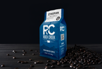 Rock Creek Coffee Roasters Ethiopian Ardi mild roast whole bean coffee bag displayed on a dark tabletop with roasted coffee beans scattered beside it against a black background.