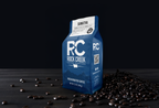 Rock Creek Coffee Roasters Sumatra Mandheling dark roast whole bean coffee bag displayed on a dark tabletop with scattered roasted coffee beans against a black background.