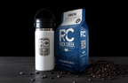 Rock Creek Coffee Roasters Sumatra Mandheling dark roast whole bean coffee bag displayed beside a white insulated travel tumbler with RC logo, with roasted coffee beans scattered on a dark tabletop against a black background.