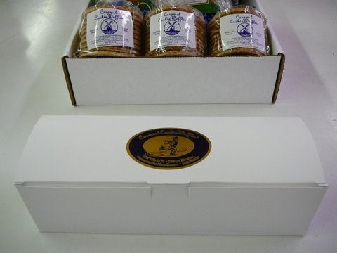White gift box with caramel cookie waffles arranged in packaging on a white surface