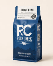 Load image into Gallery viewer, Rock Creek Coffee Roasters House Blend whole bean coffee bag standing upright on a warm off-white studio background with soft lighting and a clean product shadow.